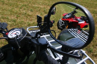 Red quad bike in rear view mirror