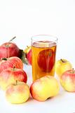 Apple juice in glass and fresh apples on white background
