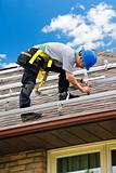 Man working on roof installing rails for solar panels