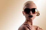 fashion shot of blond girl with golden sunglasses