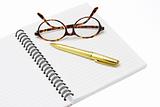 Pen and eyeglasses on a notebook 