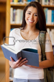 Portrait of a cute student holding a book
