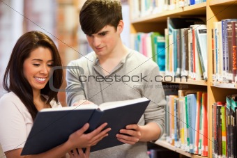 Smiling students reading a book