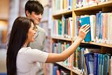 Students choosing a book on a shelf