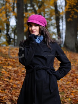Beautiful autumn woman near yellow tree outdoors in forest