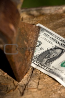A dollar being cut with an axe