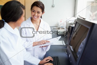 Smiling scientists working with a monitor