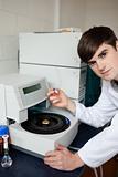 Good looking laboratory assistant using a centrifuge