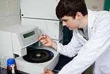 Young chemist using a centrifuge