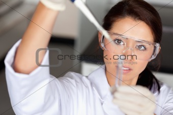 Brunette woman pouring liquid in a tube