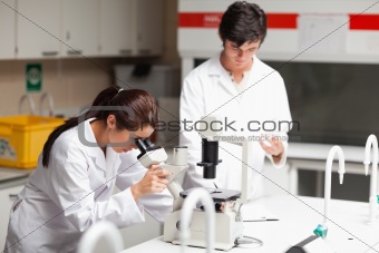 Good looking science students using a microscope