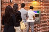 Young people queuing to withdraw cash