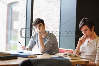 Tired young adults reviewing their notes