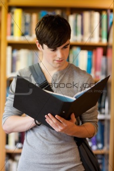 Portrait of a smiling student looking at a binder