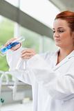 Portrait of a science student pouring liquid in an Erlenmeyer flask
