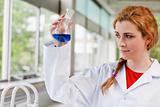 Chemist looking at a blue liquid