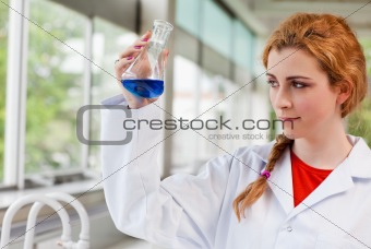 Chemist looking at a blue liquid