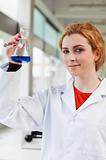Portrait of a chemist holding a blue liquid