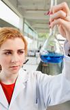 Portrait of a cute science student holding a blue liquid
