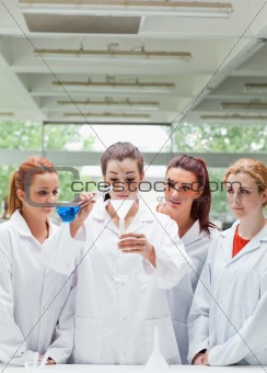 Portrait of science students pouring liquid in a flask