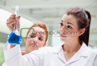 Lab partners looking at a flask