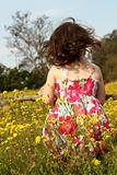 Young girl standing in a field of yellow flowers