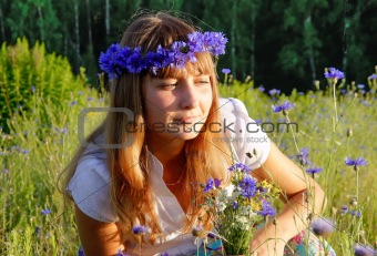 girl among the cornflowers and daisies in a meadow