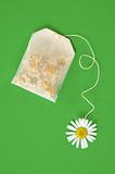 Bag of chamomile tea over green background - concept