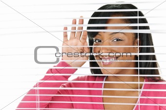 Smiling woman looking through blinds