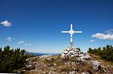 cross at a mountain top in the alps