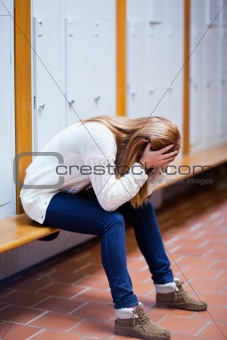 Portrait of a depressed student sitting on a bench