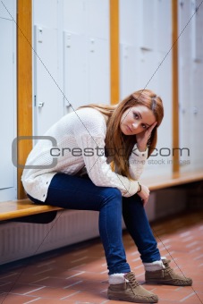 Portrait of a sad student sitting on a bench