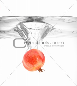 ripe pomegranate falling into water