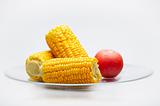 Corn Cobs and tomato on a glass plate. Small DOF