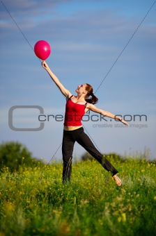 Woman jumping with a red balloon