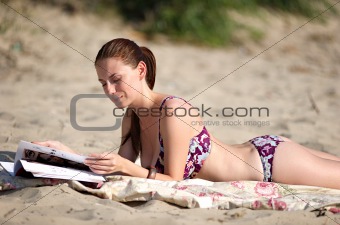 Woman reading magazine at the beach
