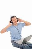 young handsome man listening to music in headphones in computer