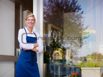 Young pretty woman working as florist in shop and smiling