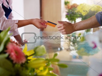 client with credit card shopping in flowers shop 