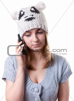 Beautiful girl in winter hat with telephone