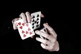 Young magicians hands holding a lot of play cards.
