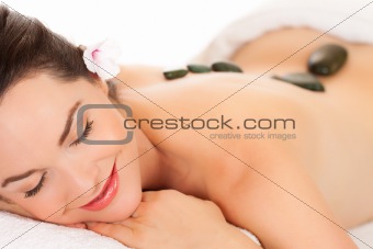 Attractive young woman getting a hot stone massage