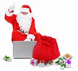 Surprised Santa claus with laptop and presents
