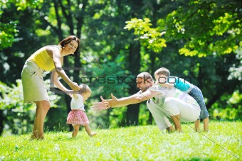 happy young couple with their children have fun at park