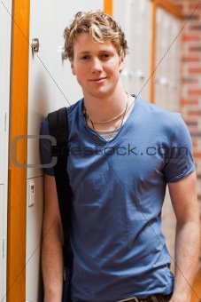 Portrait of a smiling student leaning on a locker