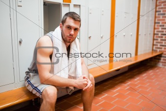 Handsome young sports student sitting on a bench