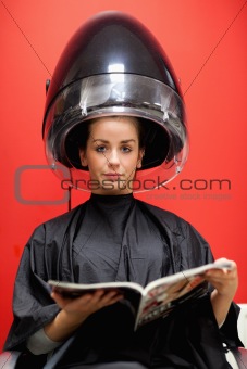Portrait of a cute woman under a hairdressing machine