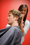 Portrait of a woman cutting a man's hair