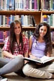 Portrait of smiling female students with a book