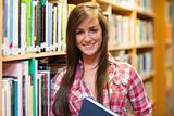 Smiling female student holding a book